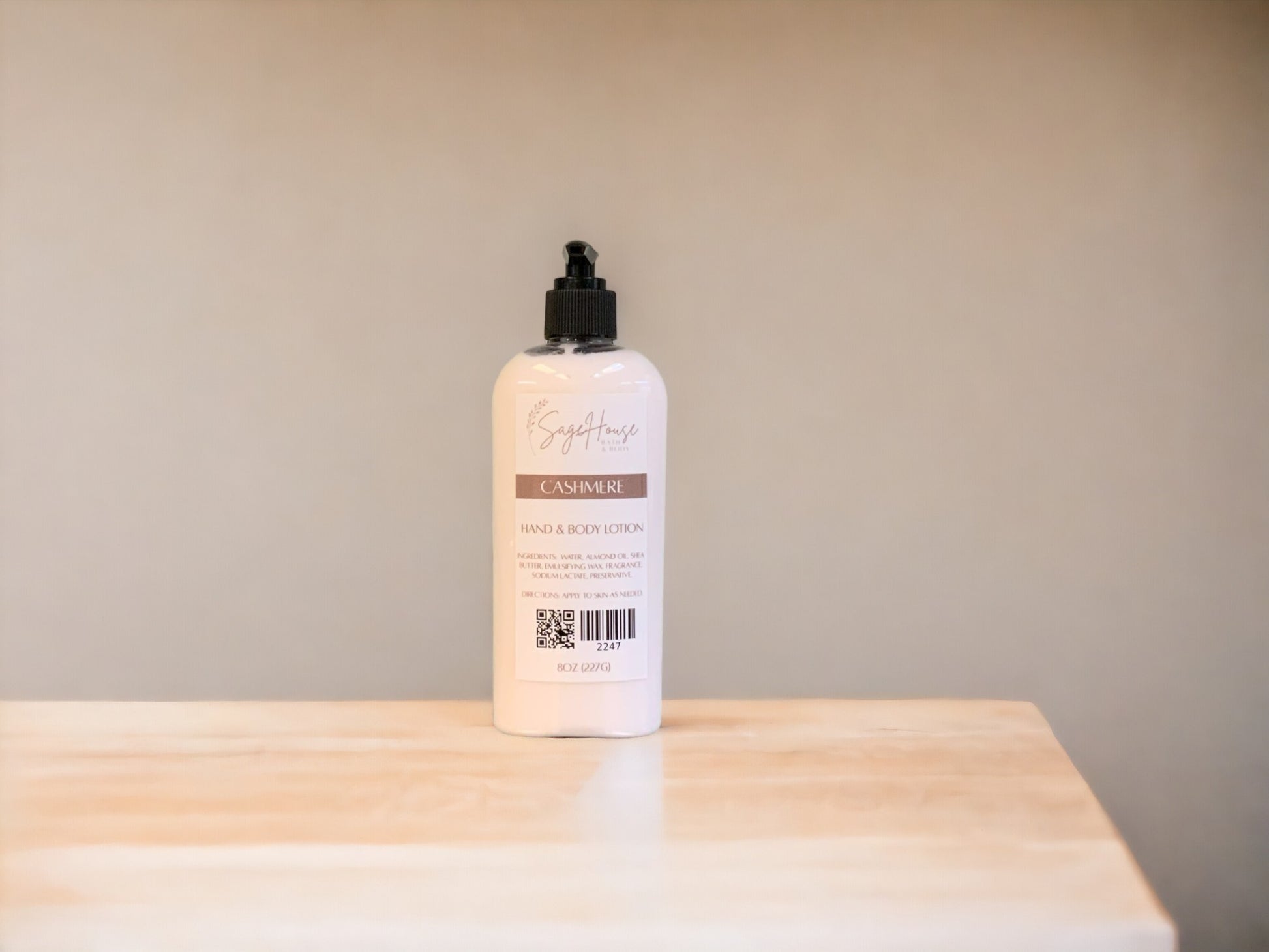 A large bottle of lotion, sitting on a light wood surface, with a tan background. 
