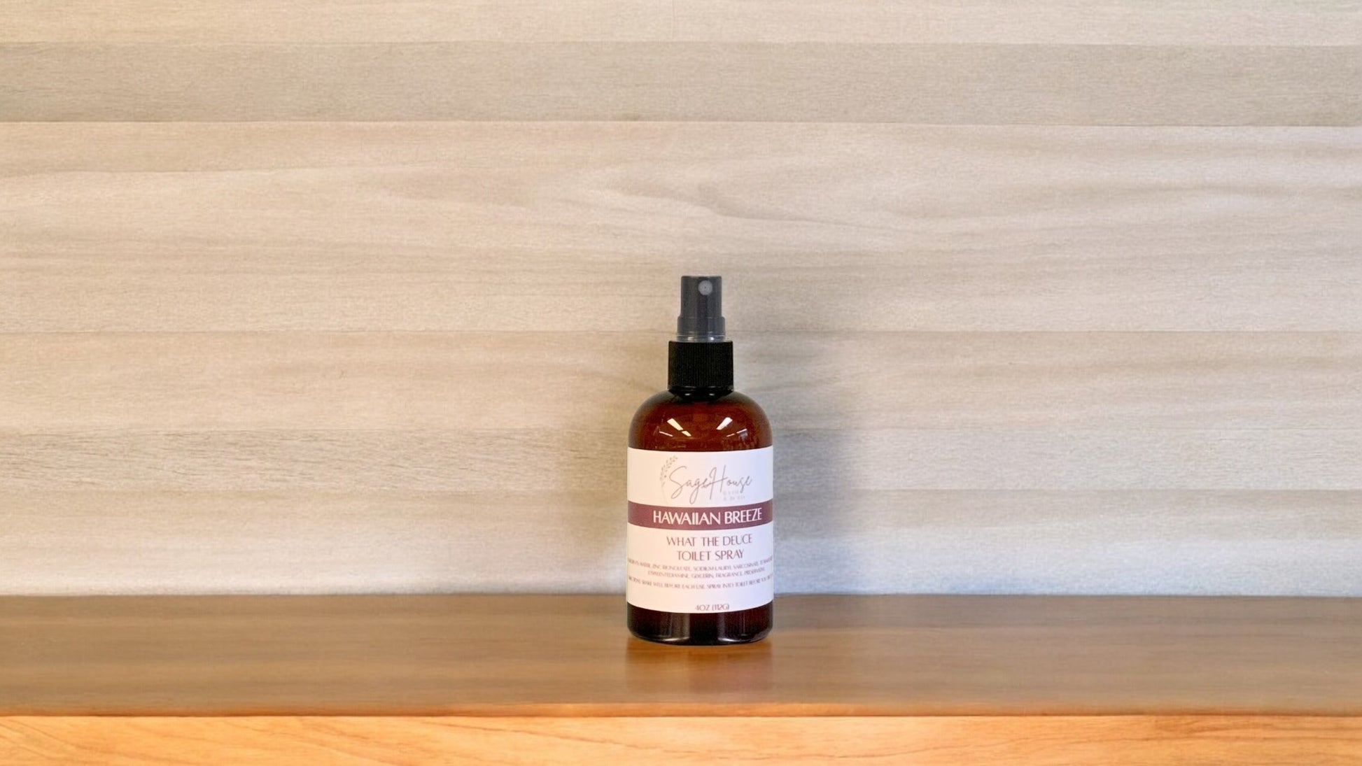 Amber colored spritz bottle with hawaiian breeze label, on wood surface
