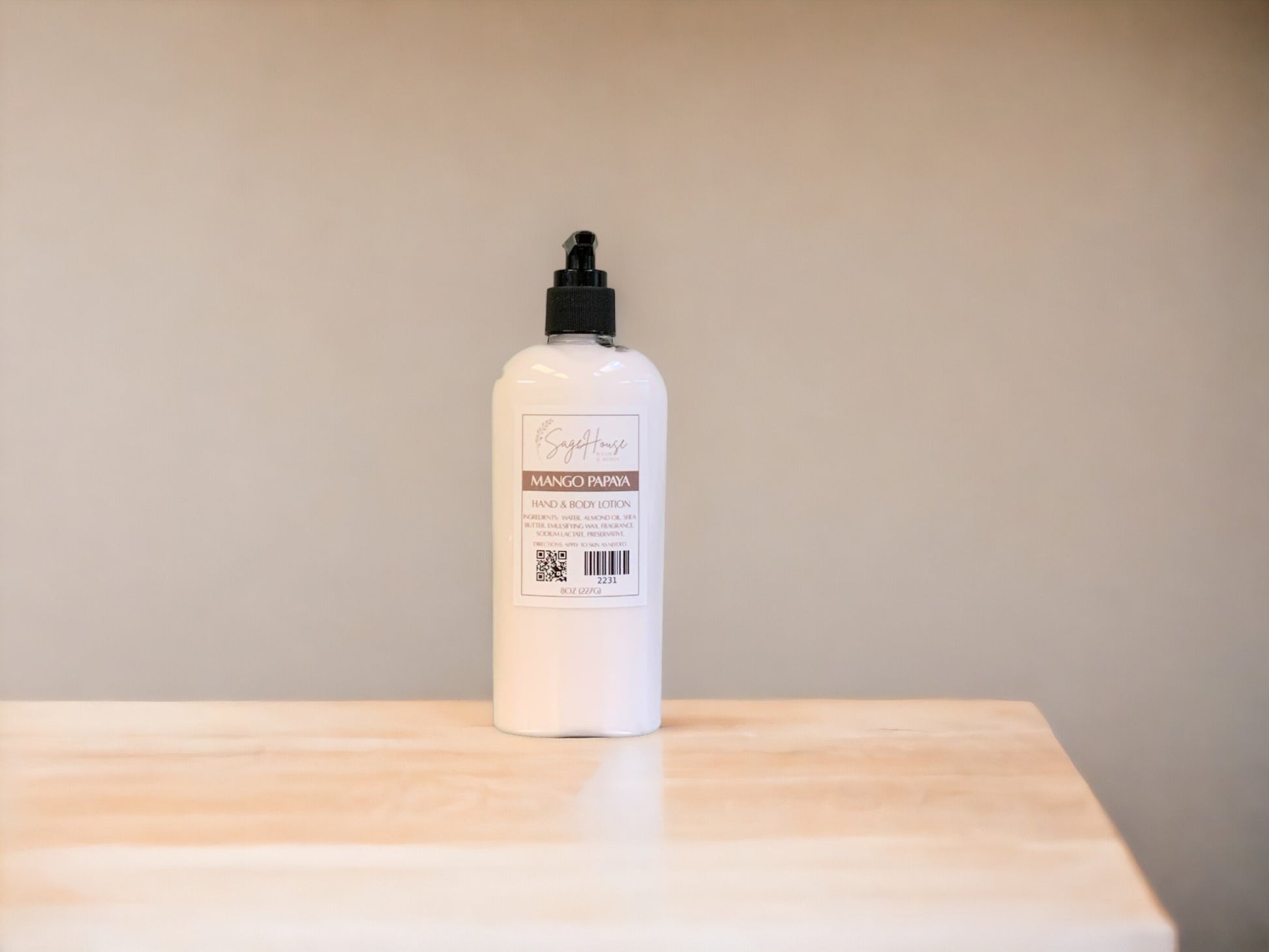 A large bottle of lotion, sitting on a light wood surface, with a tan background. 