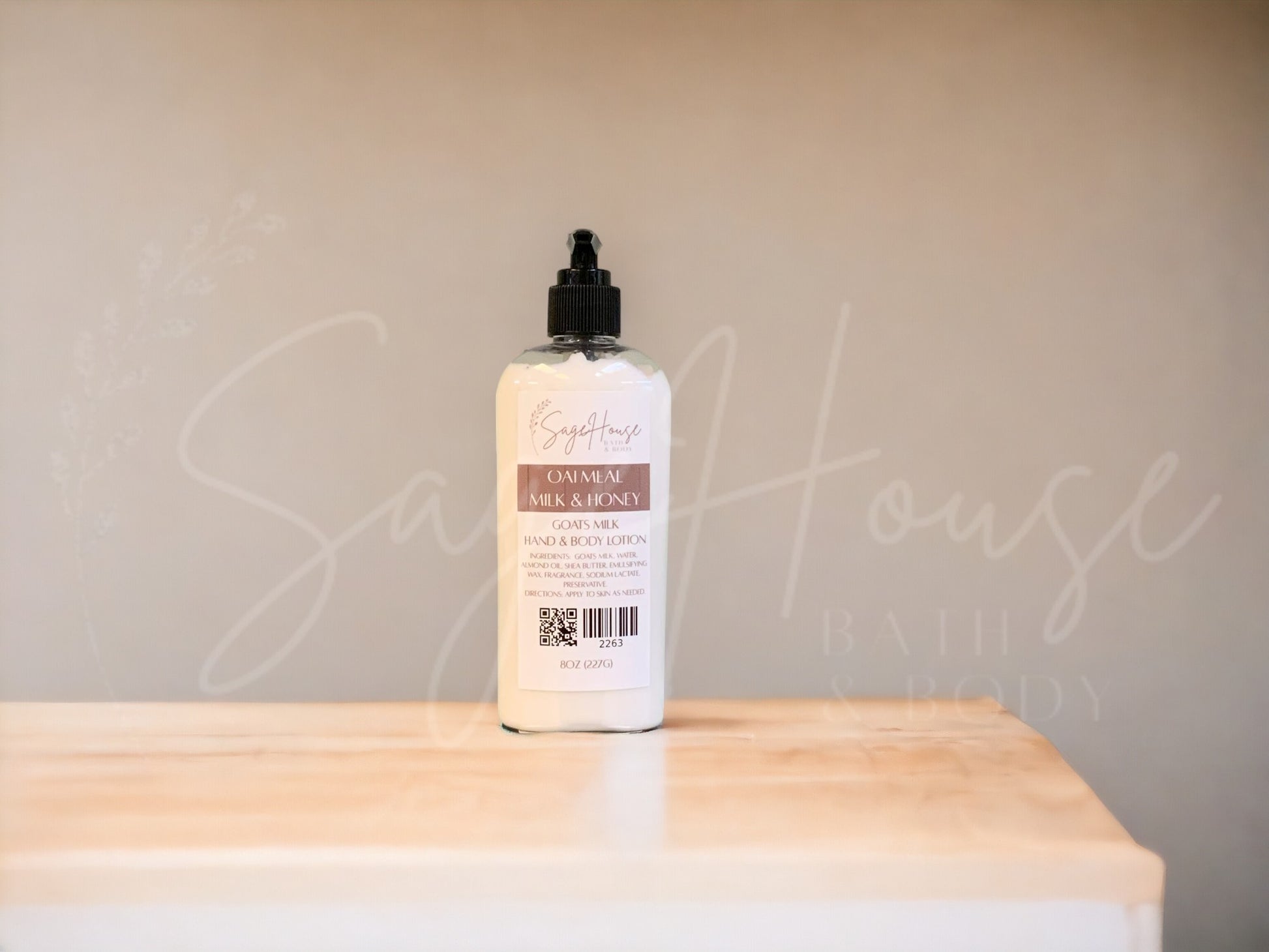 Large bottle of lotion with black pump top on a wooden surface with a neutral background