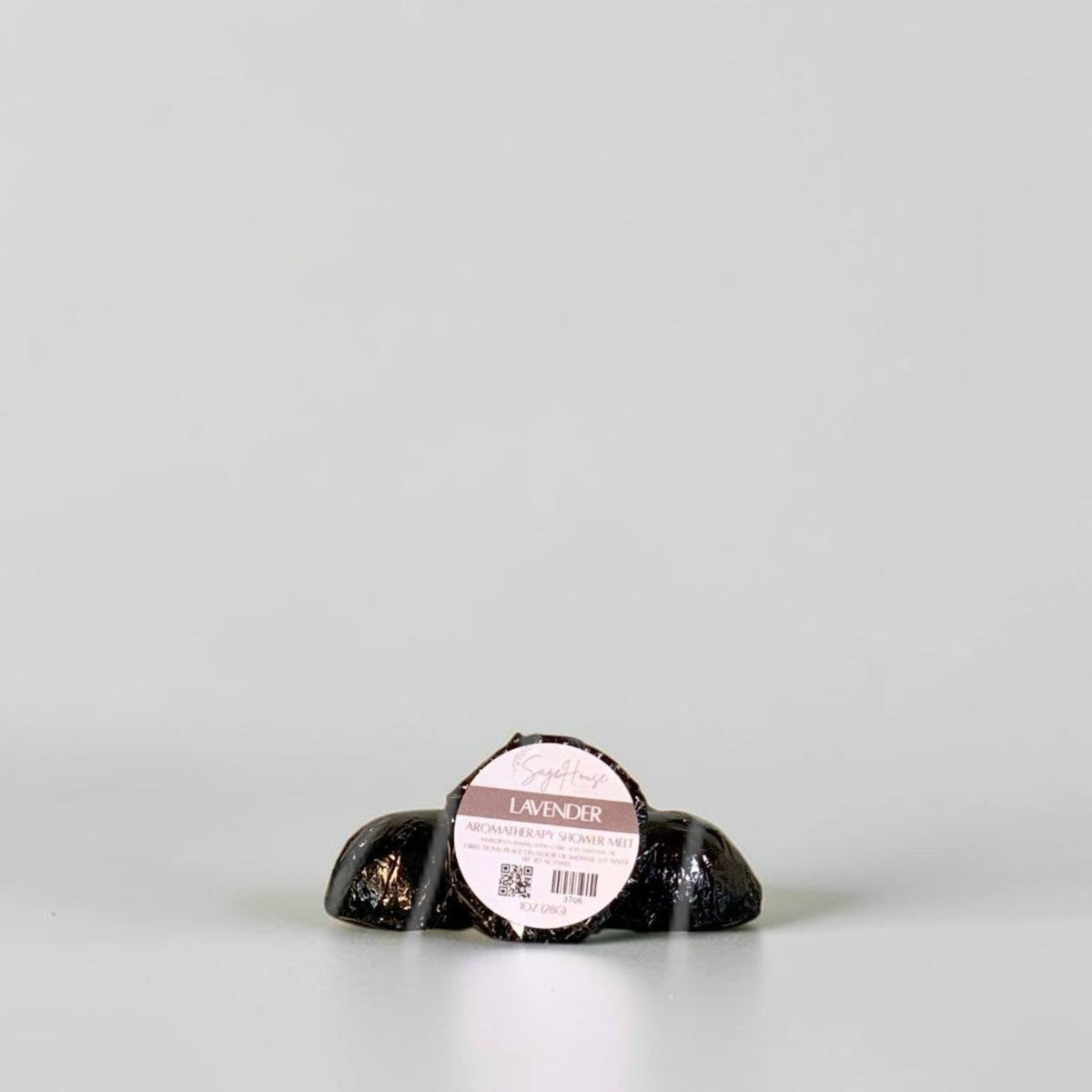 One labeled shower melt propped in front of 2 other shower melts. Sitting on a white background.