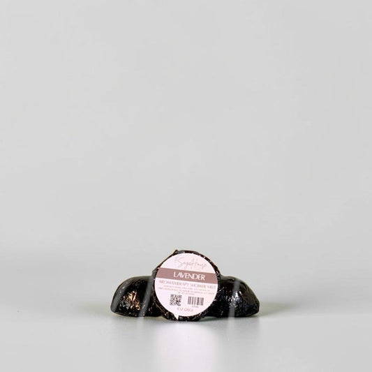 One labeled shower melt propped in front of 2 other shower melts. Sitting on a white background.