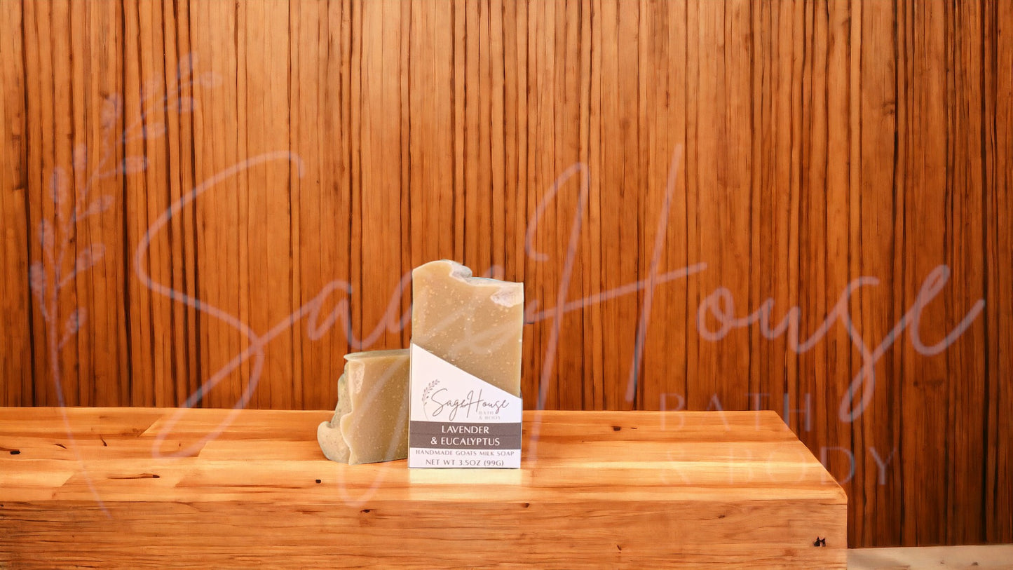 A tan bar of soap in a white labeled box, on a wood surface.