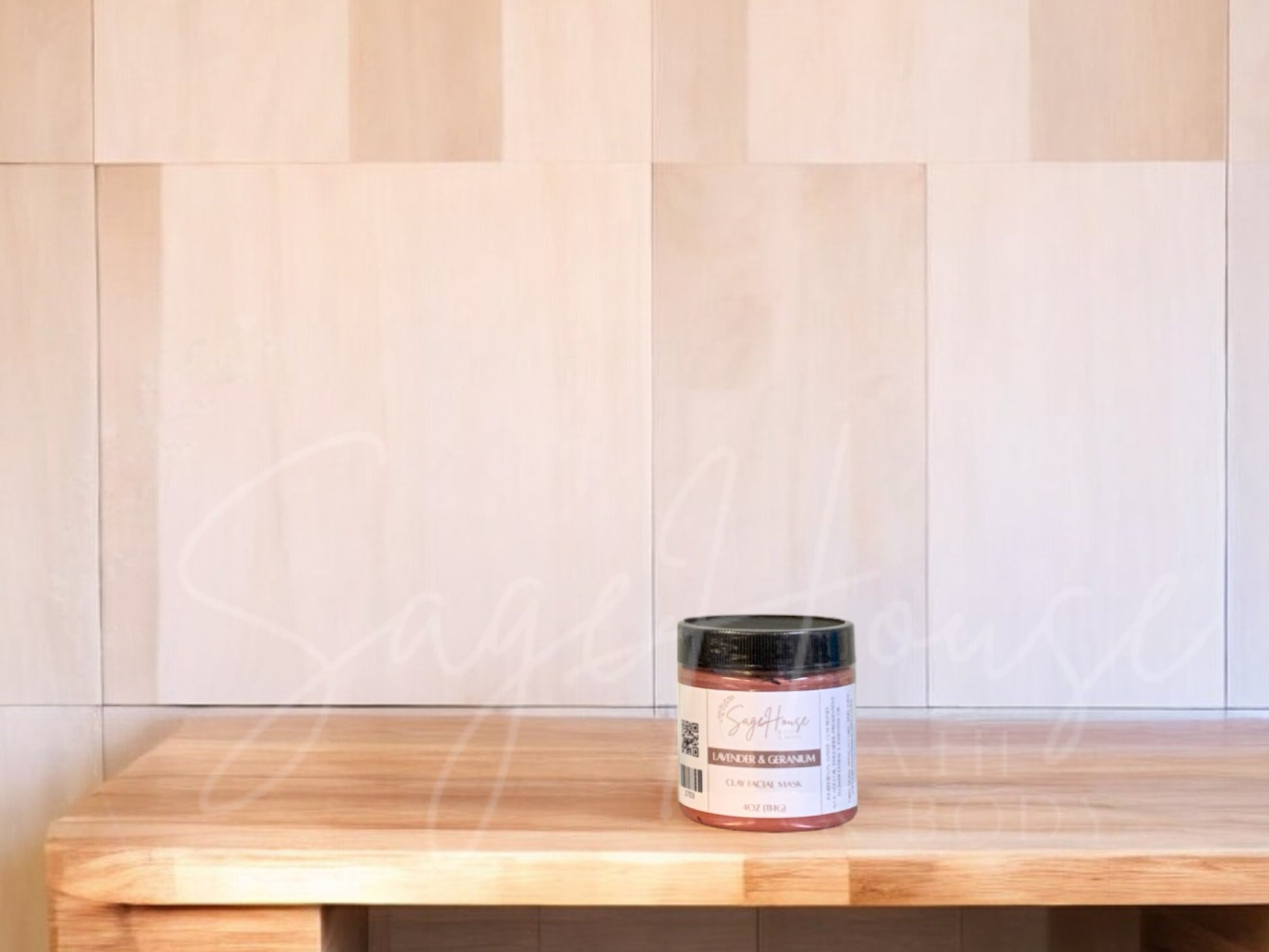 A face mask product in a small container, with a beige background resembling a wooden texture.