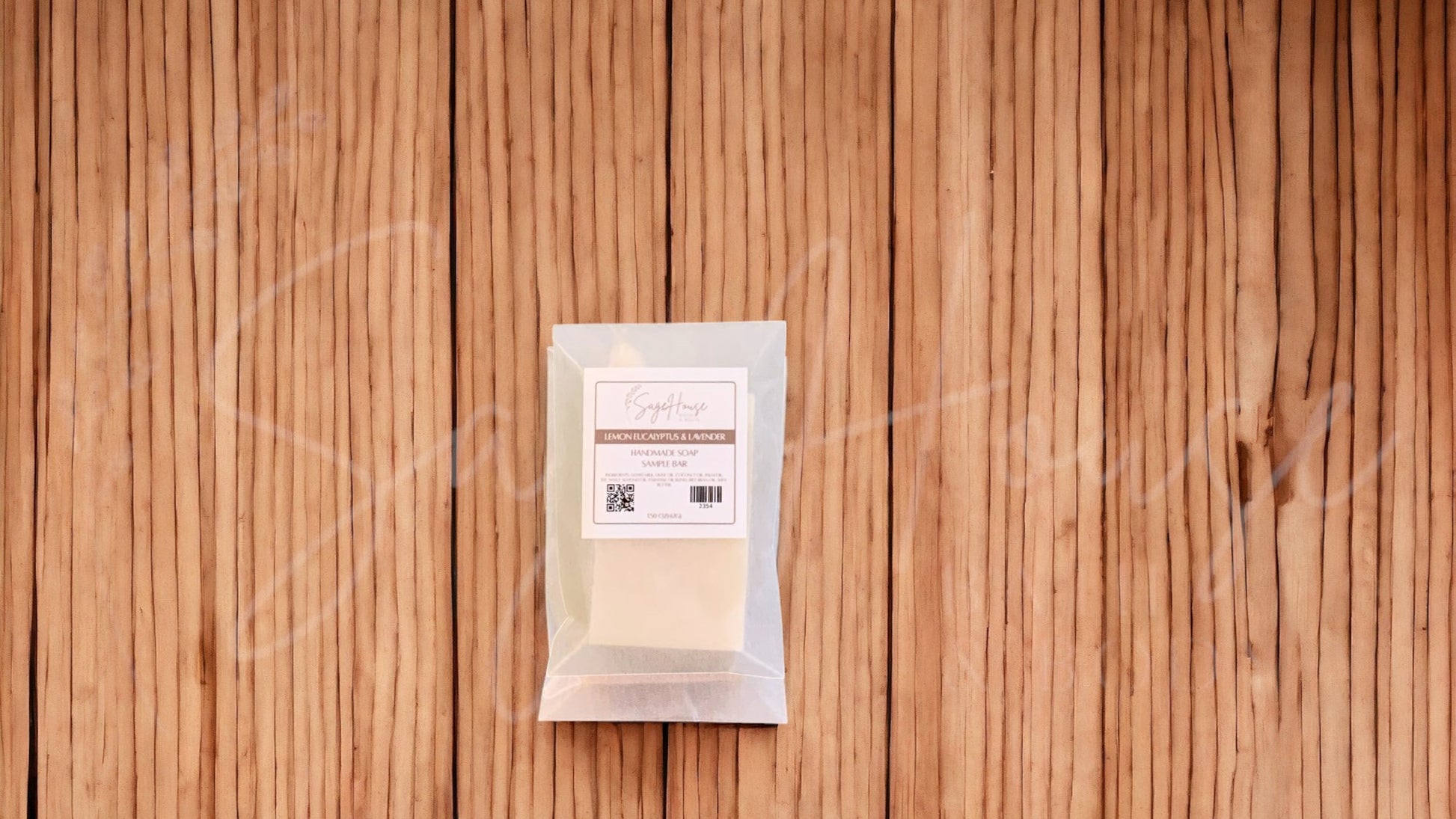 A sample soap bar in a glassine bag. placed on a wood surface.