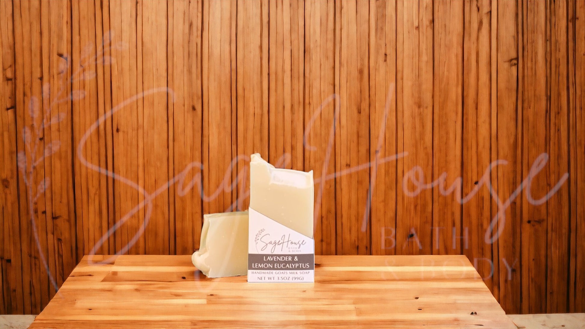 A cream colored soap bar in a white labeled box. on a wood surface.