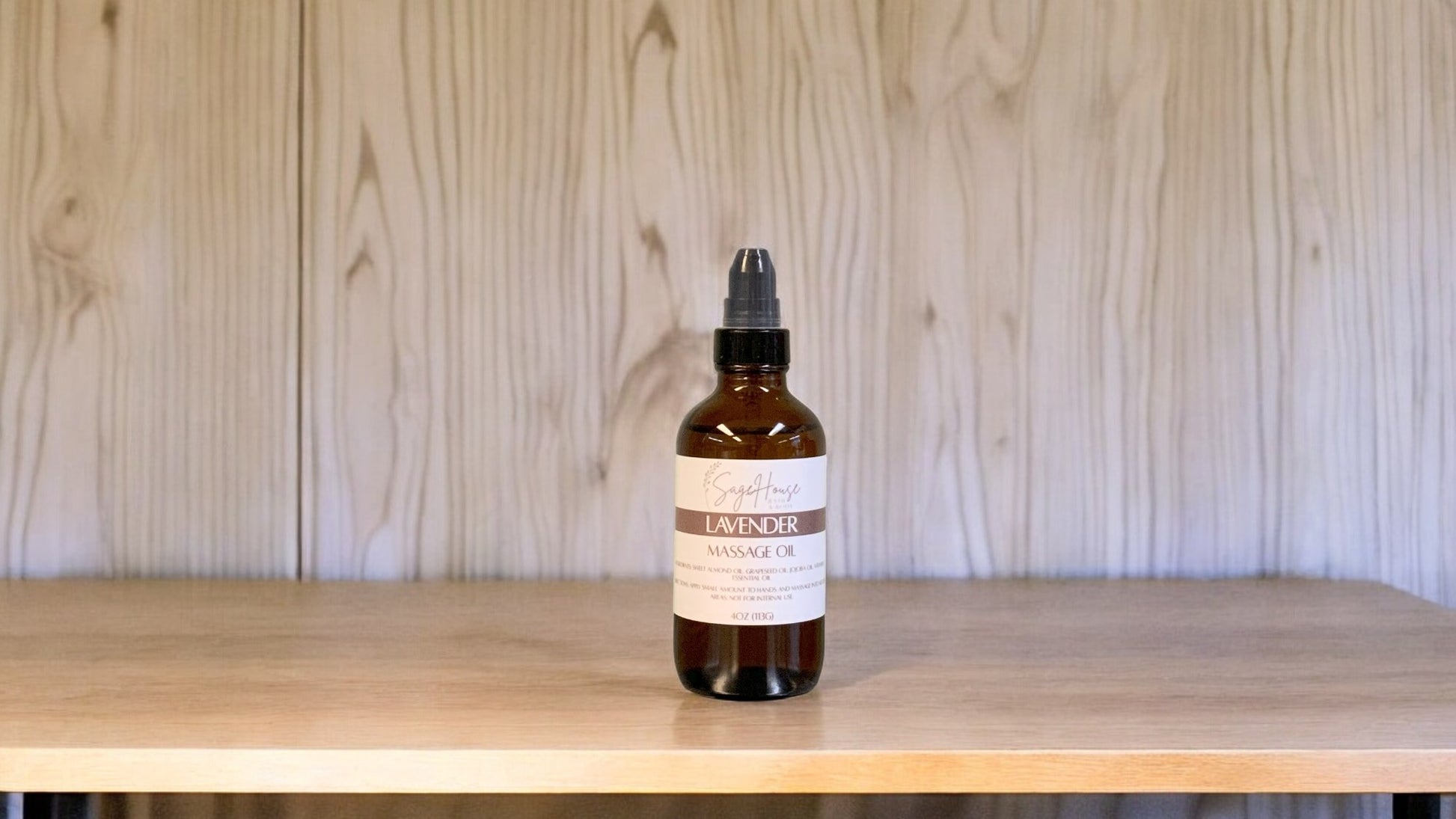 A Bottle with a treatment pump, labeled with 'lavender Massage Oil', positioned on a wooden surface.
