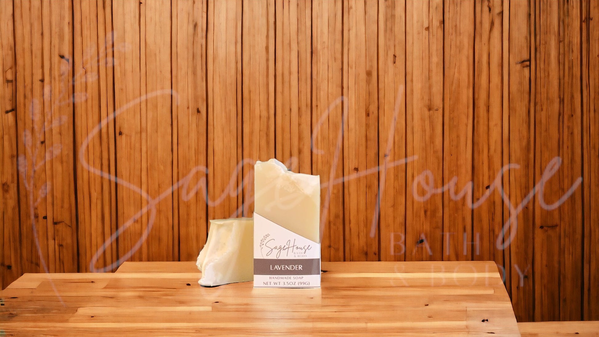 A tan bar of soap in a white labeled box, on a wood surface.