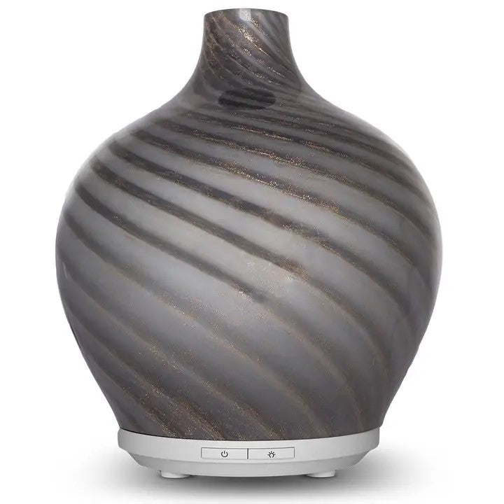 An essential oil diffuser with a white base and a blown glass top with gray and shimmery swirls