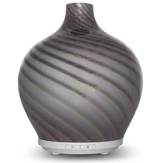 An essential oil diffuser with a white base and a blown glass top with gray and shimmery swirls