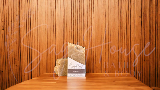 A tan bar of soap in a white labeled box, on a wood surface.