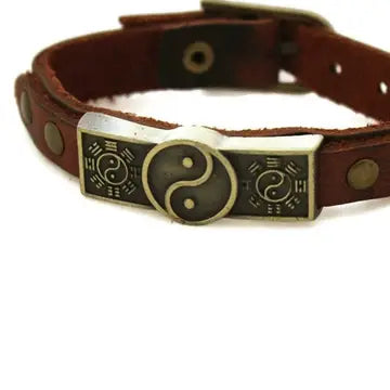 bracelet with brown leather and bronze faceplate with a yin & yang design.