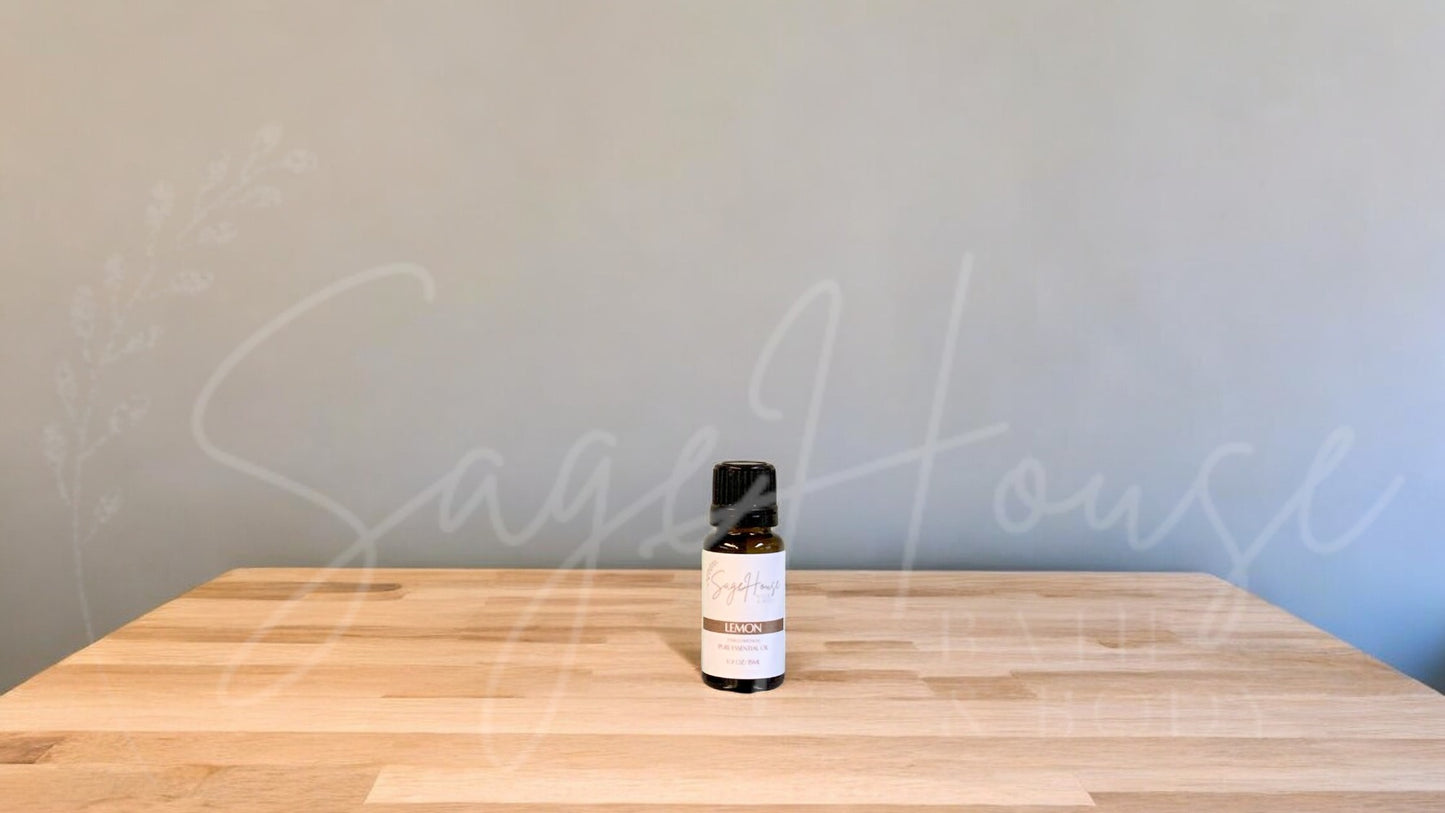 A small bottle of Lemon essential oil is placed on a wooden surface with a plain background.