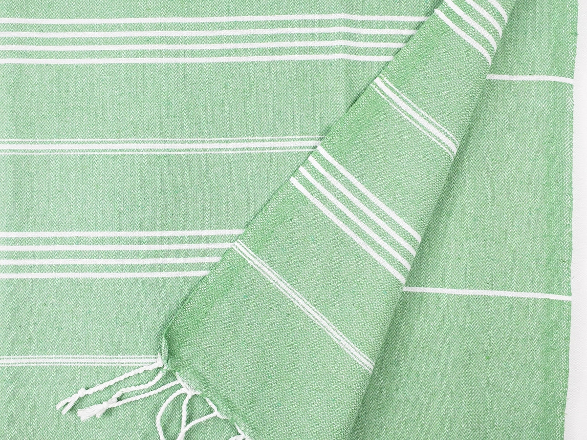 Light green Turkish cotton towel, folded onto itself, on a white background.