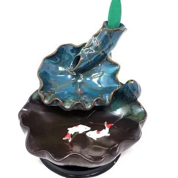 A cone incense burner with a lotus leaf over a pond with fish. Incense cone is placed on the top