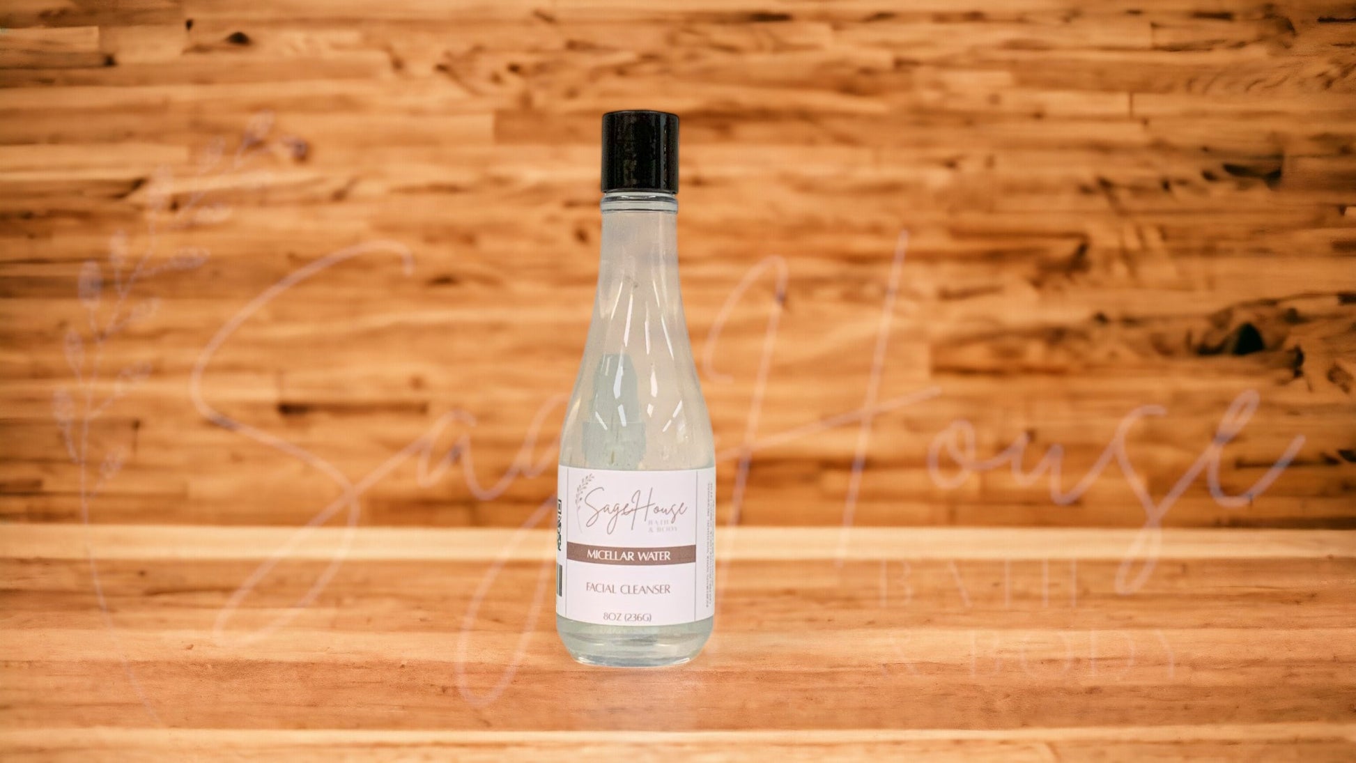 A transparent bottle with a black lid, placed on a wooden surface with a wooden background.