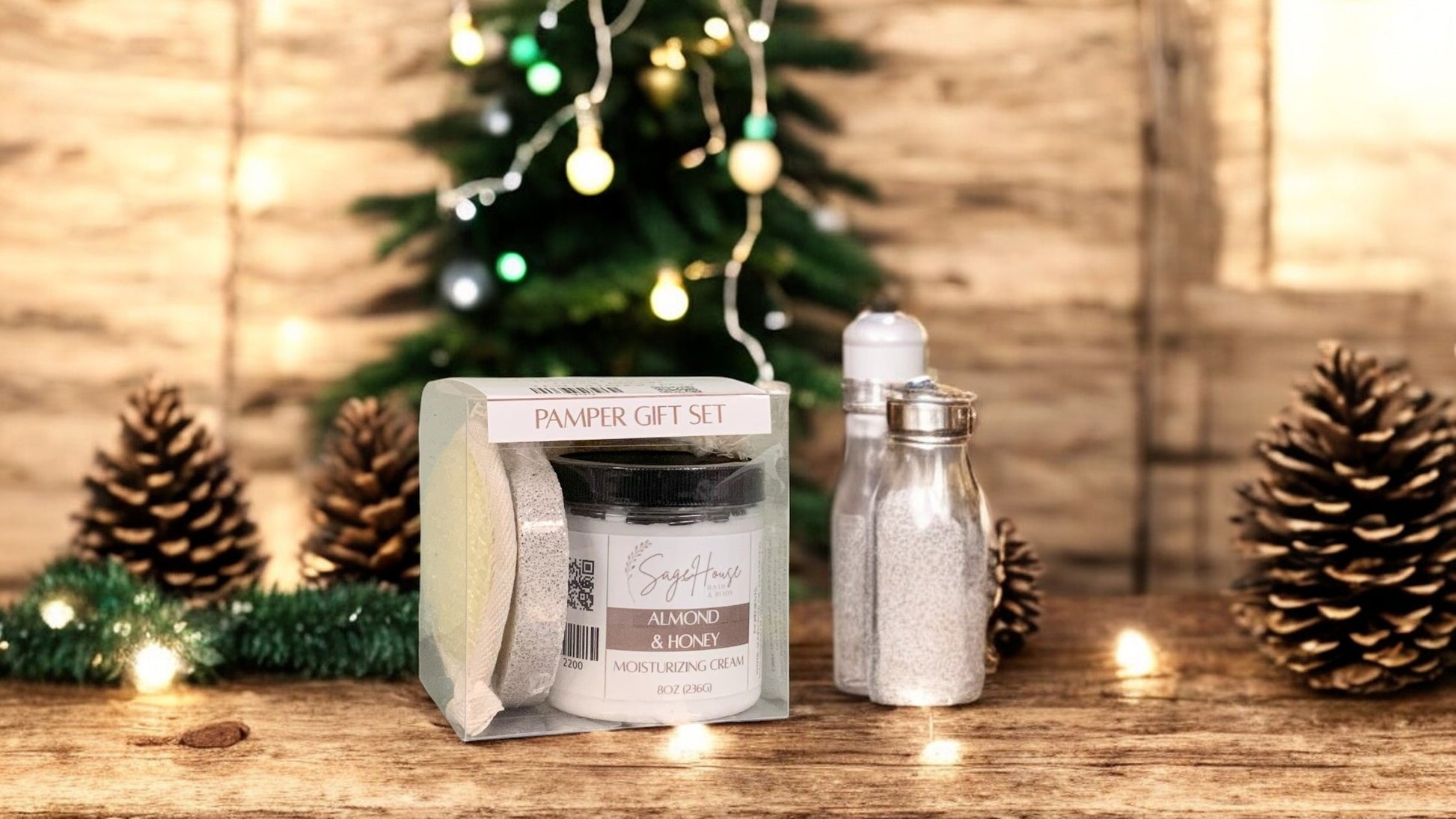 A square clear gift set including moisturizing cream, displayed on a wooden table with a Christmas tree and pine cones in the background.