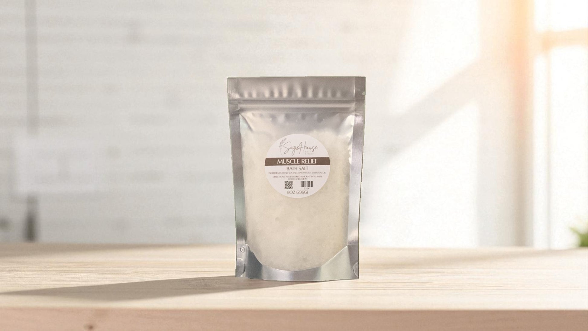 Silver packaging with a clear window of white salt labeled "muscle relief" on a wood surface.