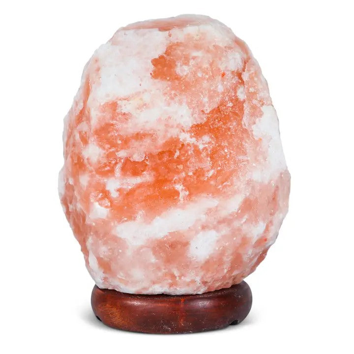 A natural shaped pink Himalayan salt lamp on a wooden base.