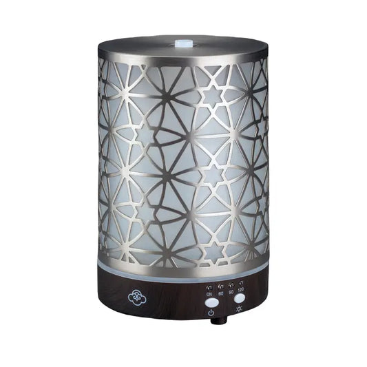 A modern electric aromatherapy diffuser with a geometric pattern on the metal cover, featuring control buttons at the base.