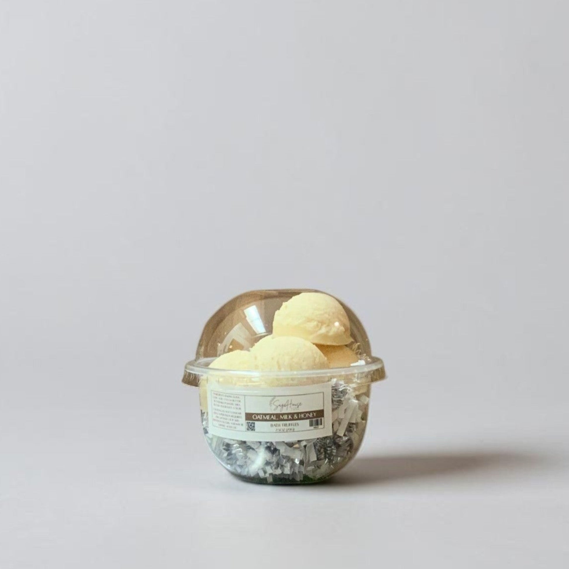 a container of bath truffles on a grey background.