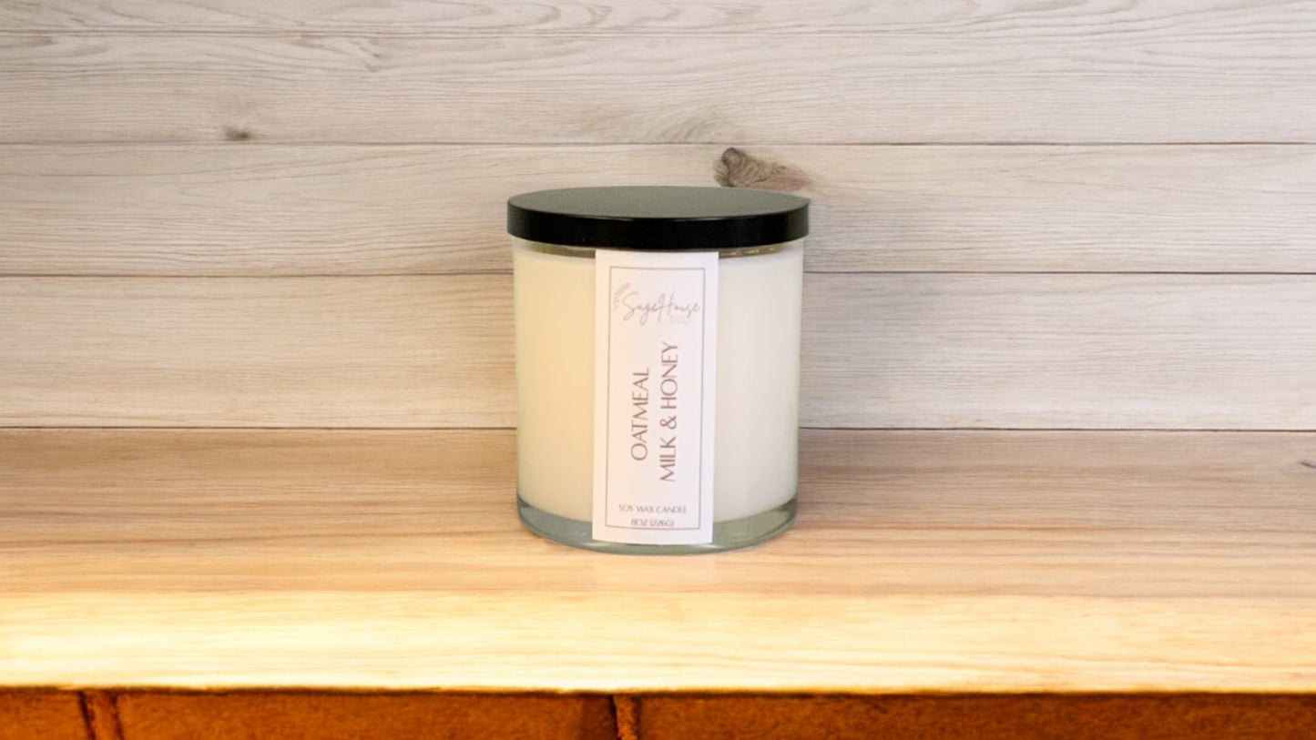 A white soy wax candle in a clear container, placed on a wooden surface, with a label on the front.