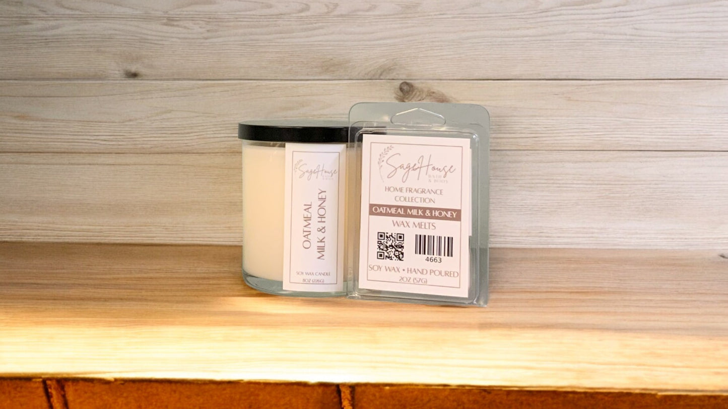 A white soy wax candle in a clear container, next to a clear clamshell wax melt package. placed on a wooden surface, with a label on the front.