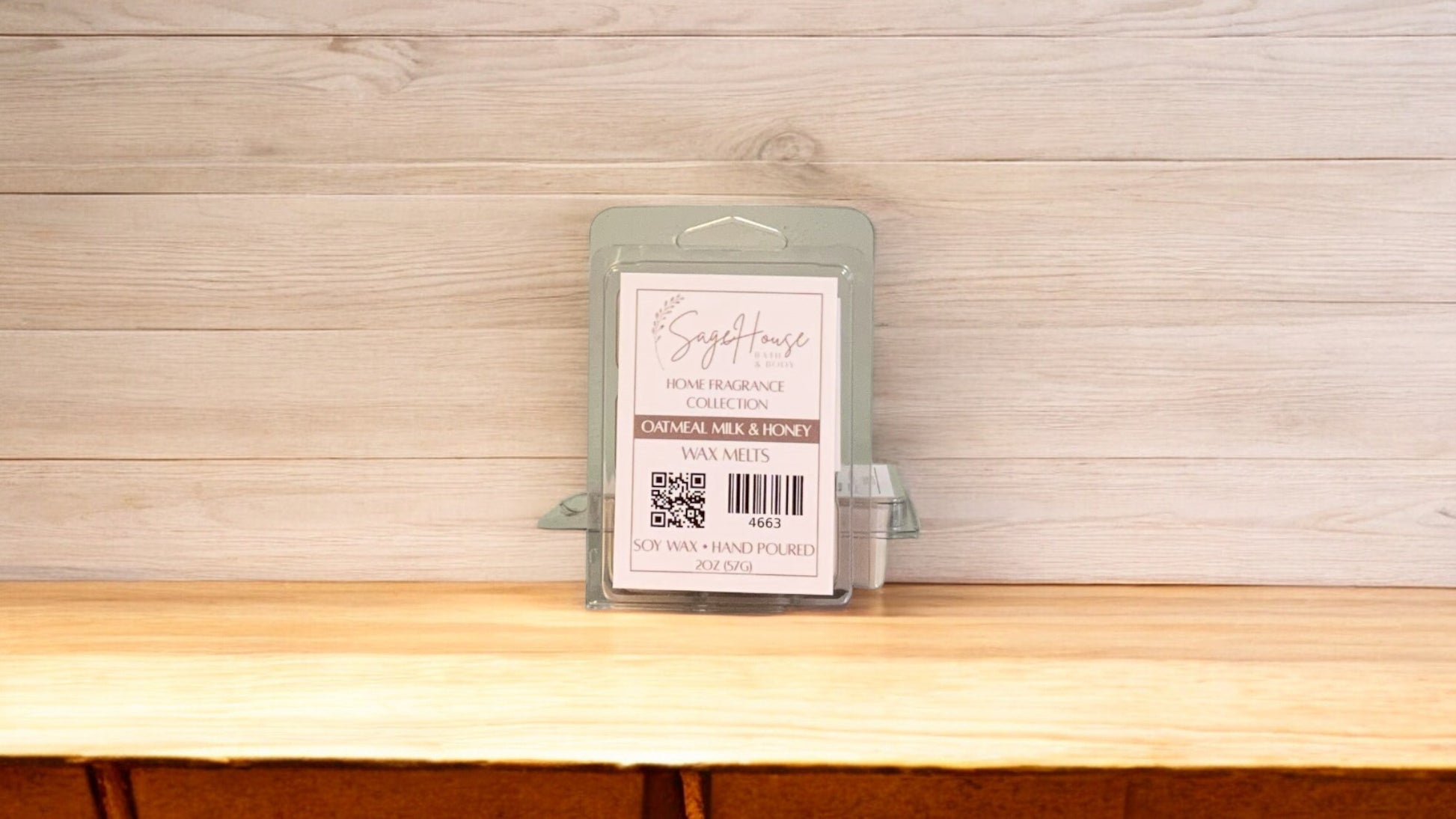A clear clamshell container holding 6 wax melt cubes with a label on top, placed on a wooden surface against a wooden background.