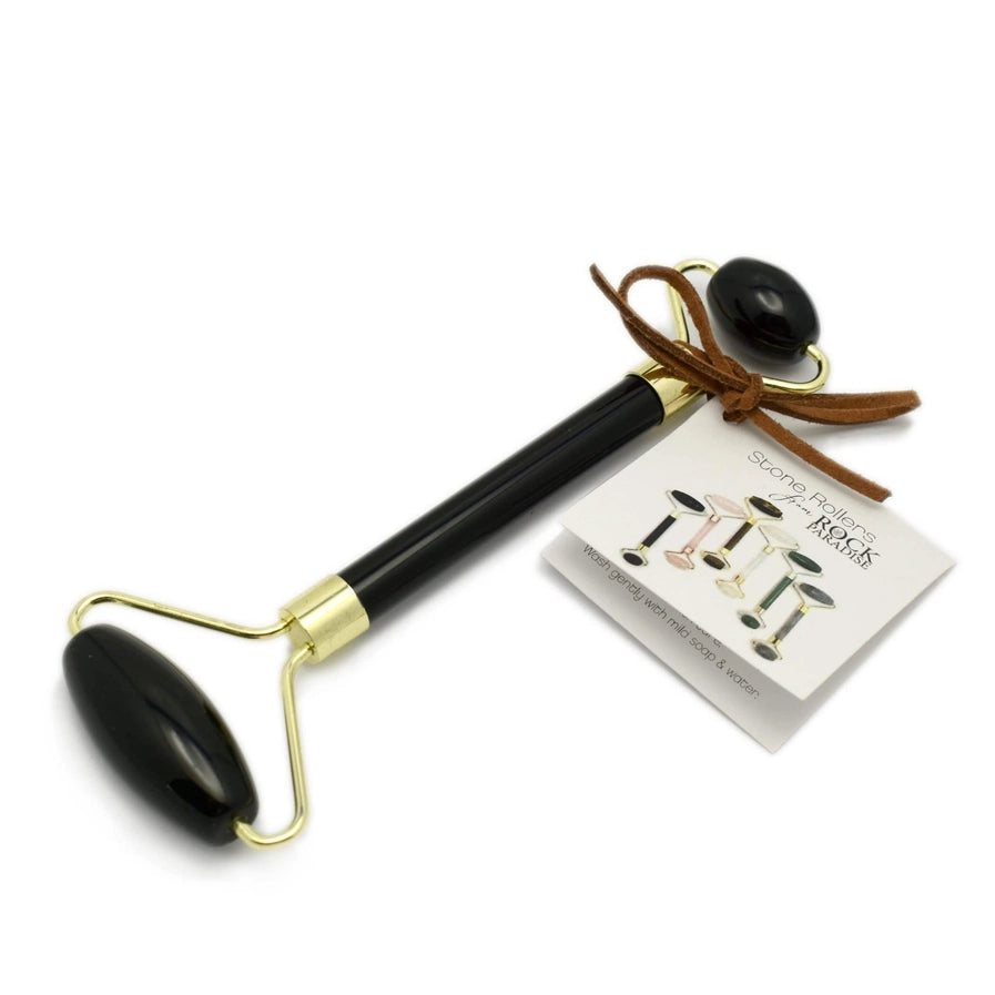 Obsidian roller with gold hardware and a roller on each end. On a white background