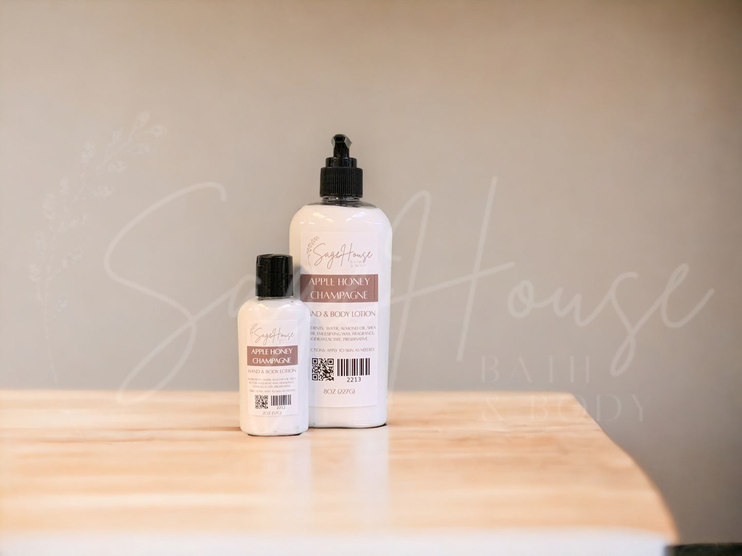 2 sizes of bottles of lotion, sitting on a wood surface with neutral background