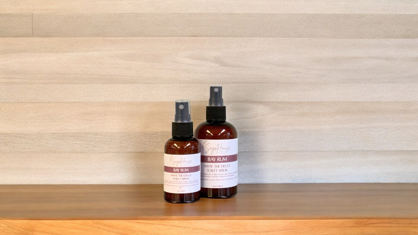 2 Amber colored spritz bottles with bay rum label, on wood surface