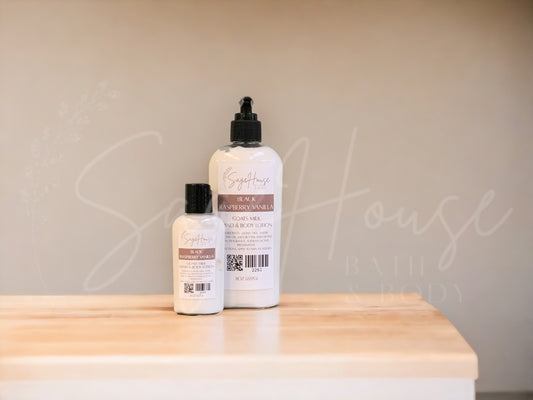 Two bottles of lotion with black caps on a wooden surface with a neutral background