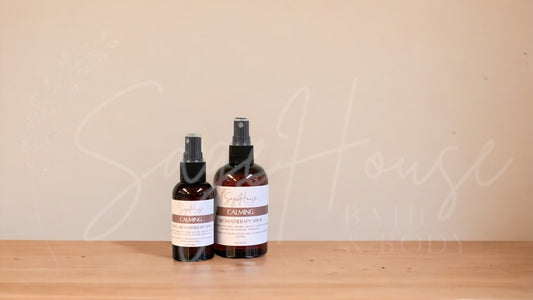 2 Amber colored spritz bottles with calming labels, on wood surface