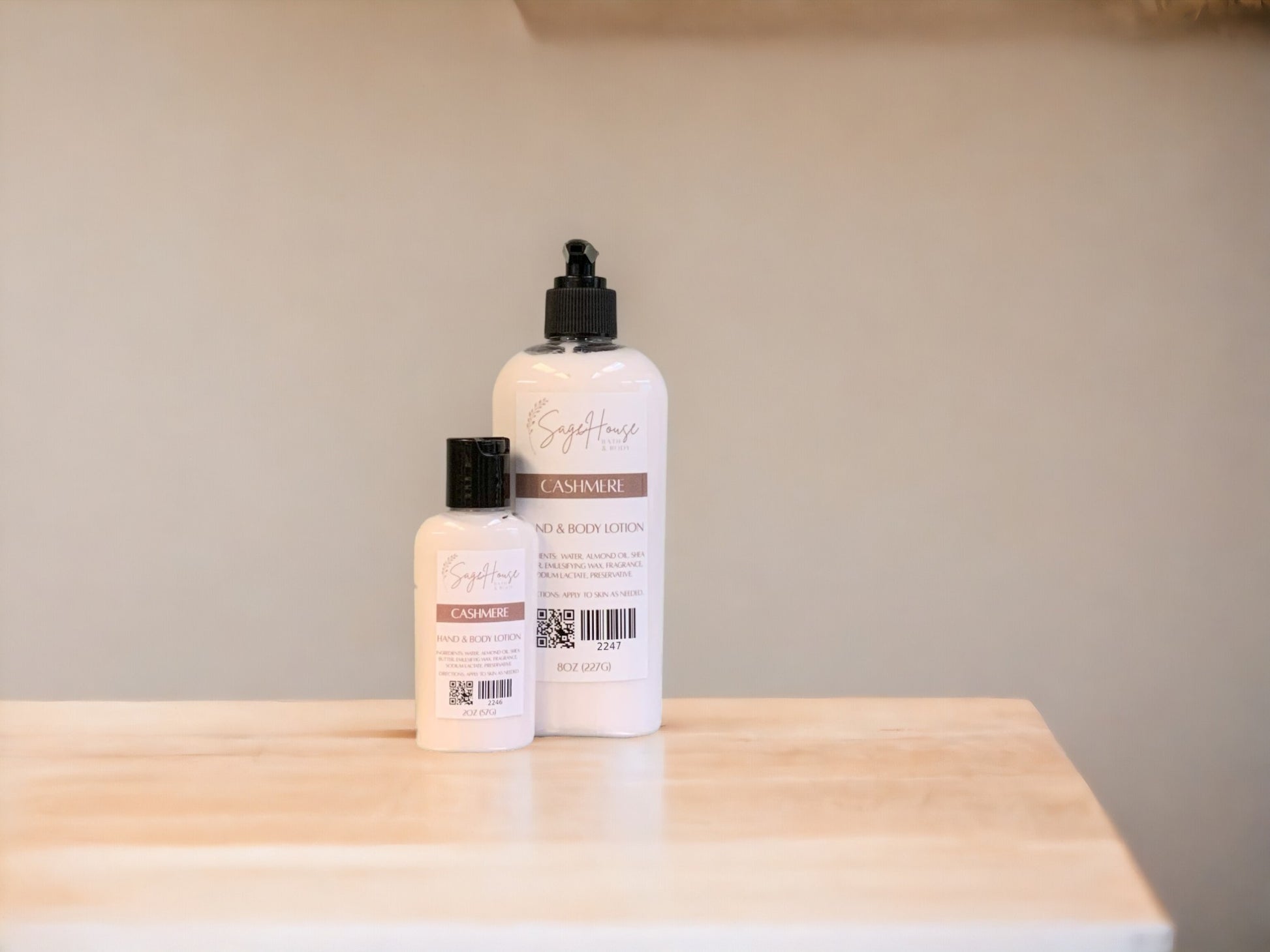 Two bottles of lotion with black caps on a light wooden surface with a tan background