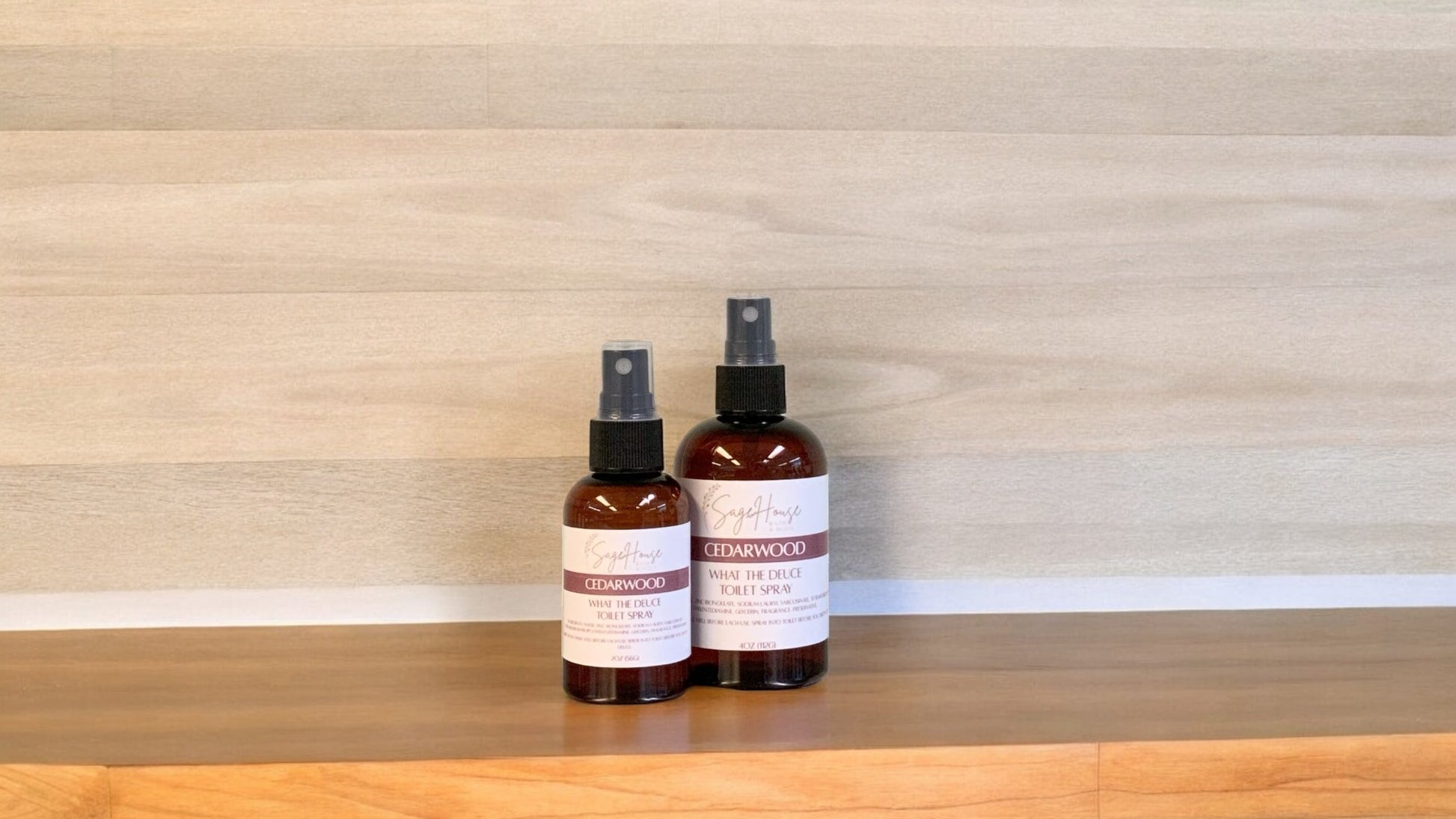 2 Amber colored spritz bottles with cedarwood labels, on wood surface