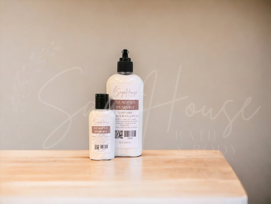 Two bottles of lotion with black caps on a wooden surface with a neutral background