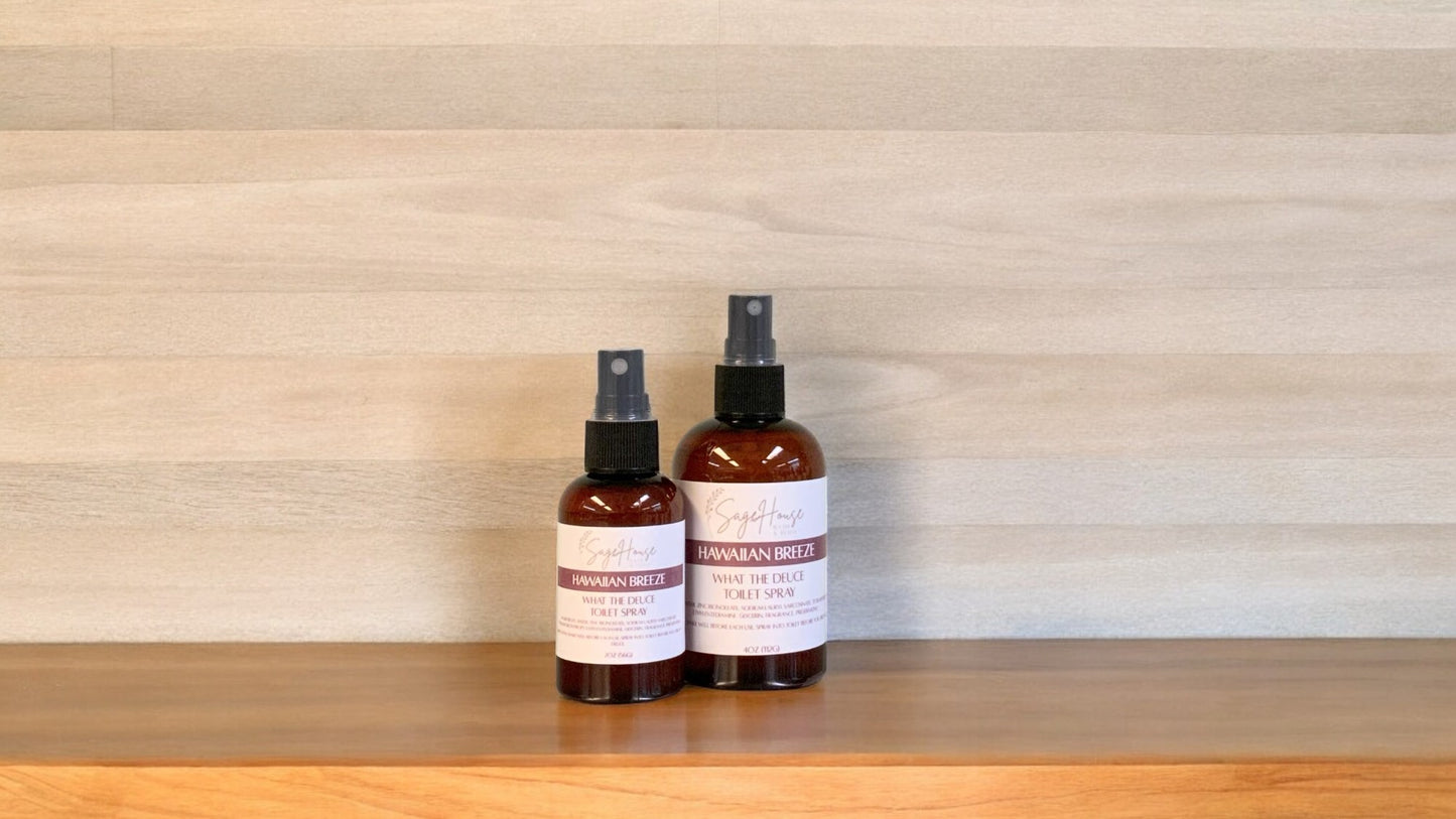 2 Amber colored spritz bottles with hawaiian breeze labels, on wood surface