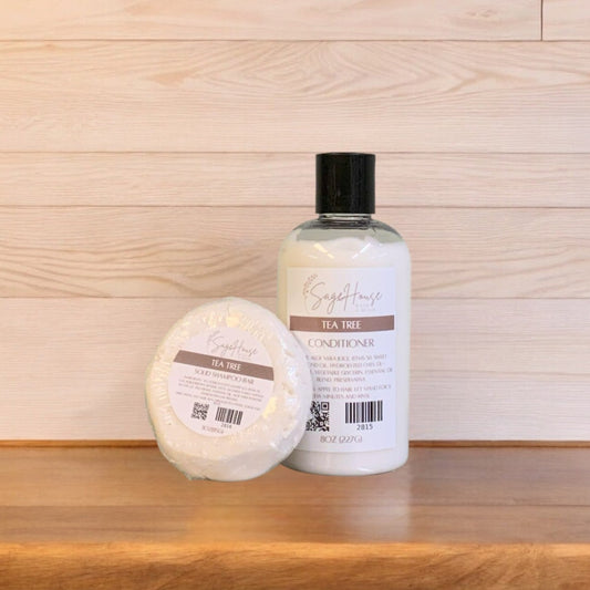 A Tea Tree shampoo bar & bottle of conditioner on a wooden surface.