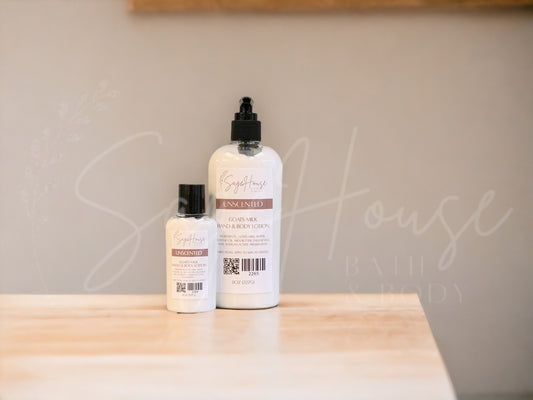 A small bottle of lotion next to a large bottle of lotion, sitting on a light wood surface, with a tan background. Has SageHouse logo inlayed