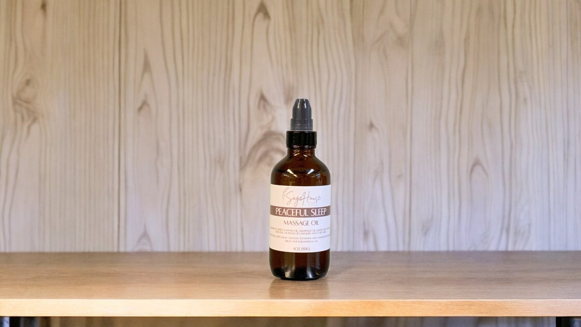 A Bottle with a treatment pump, labeled with 'Peaceful sleep Massage Oil', positioned on a wooden surface.