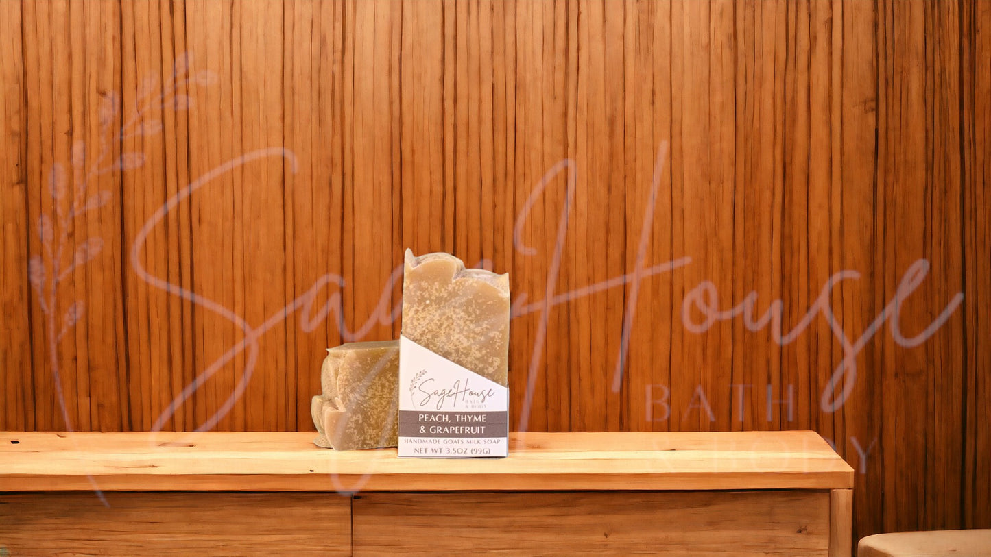 A tan bar of soap in a white labeled box, on a wood surface.