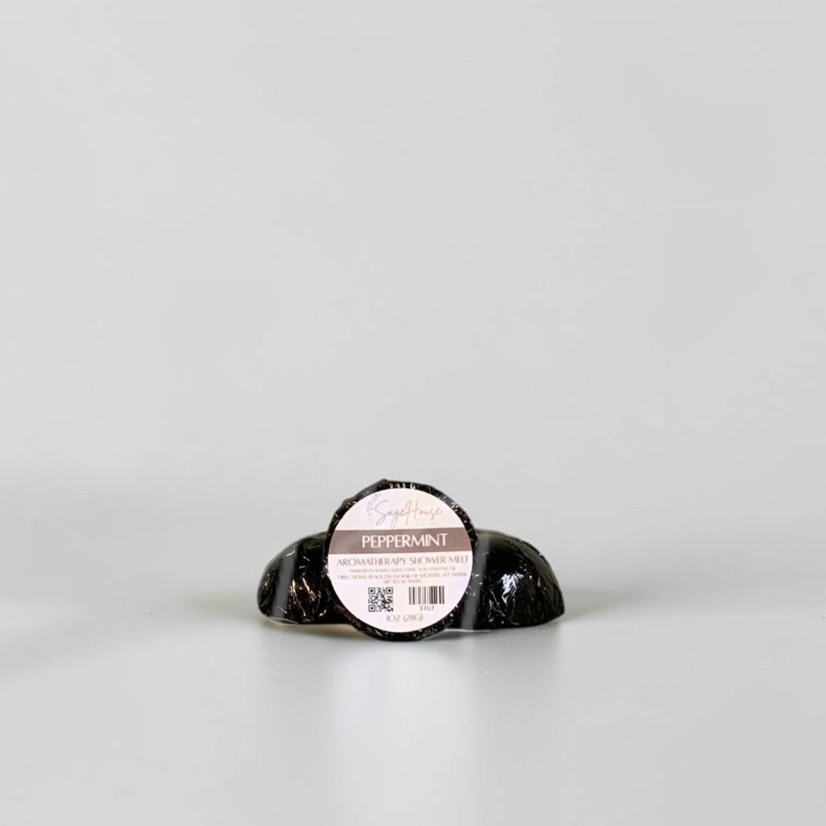 One labeled shower melt propped in front of 2 other shower melts. Sitting on a white background.