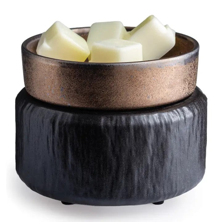 A black, primitive-style fragrance warmer with a dish containing white wax cubes on top.