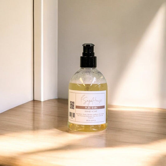 A clear plastic bottle of hand soap with a black cap, placed on a wooden surface with natural lighting.