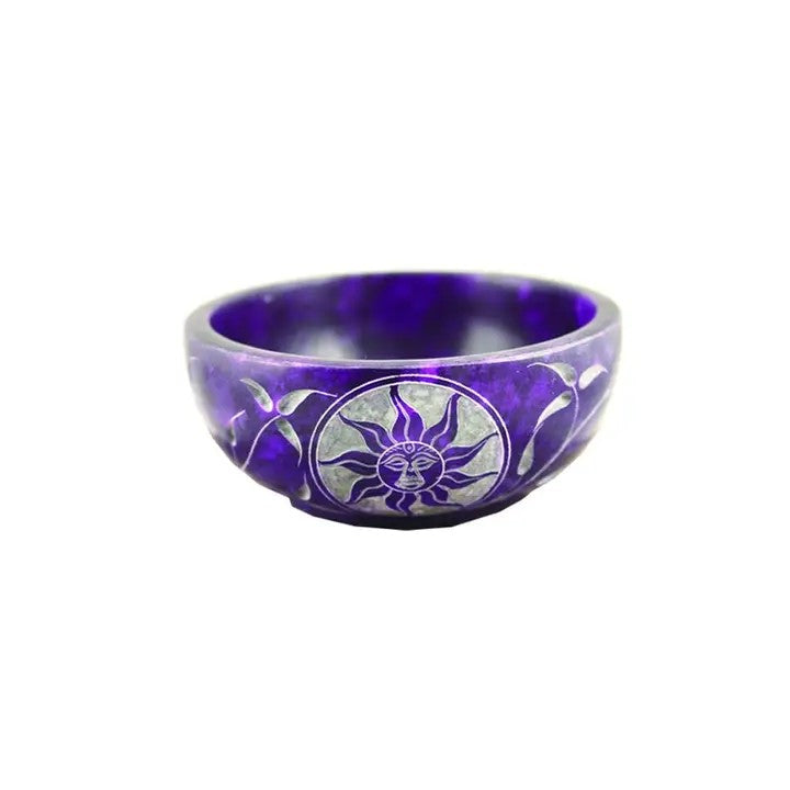 A Soapstone Bowl in Purple color, with flower and sun designs on a white background