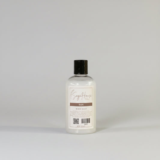 Bottle of "rain" body wash on a wooden surface with a light background