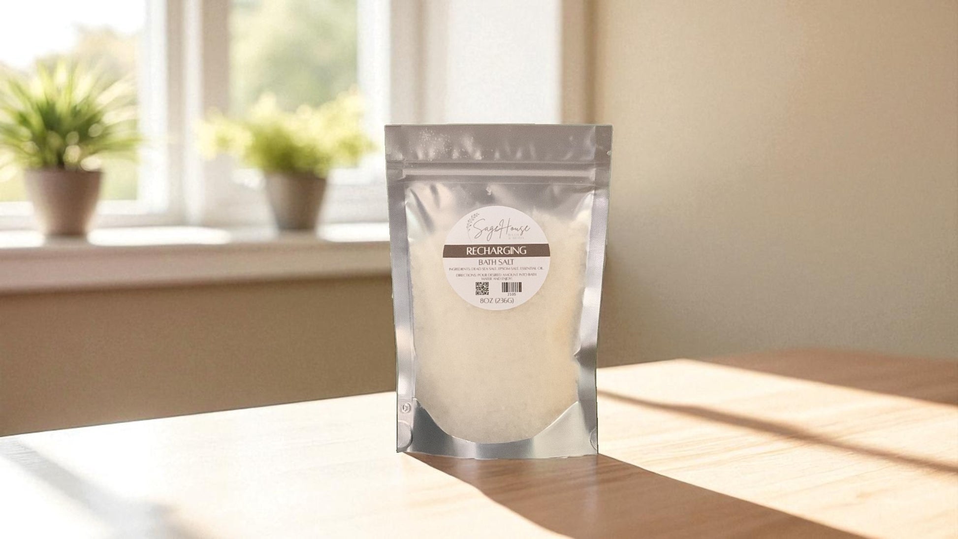 Silver packaging with a clear window of white salt labeled "recharging" on a wood surface.