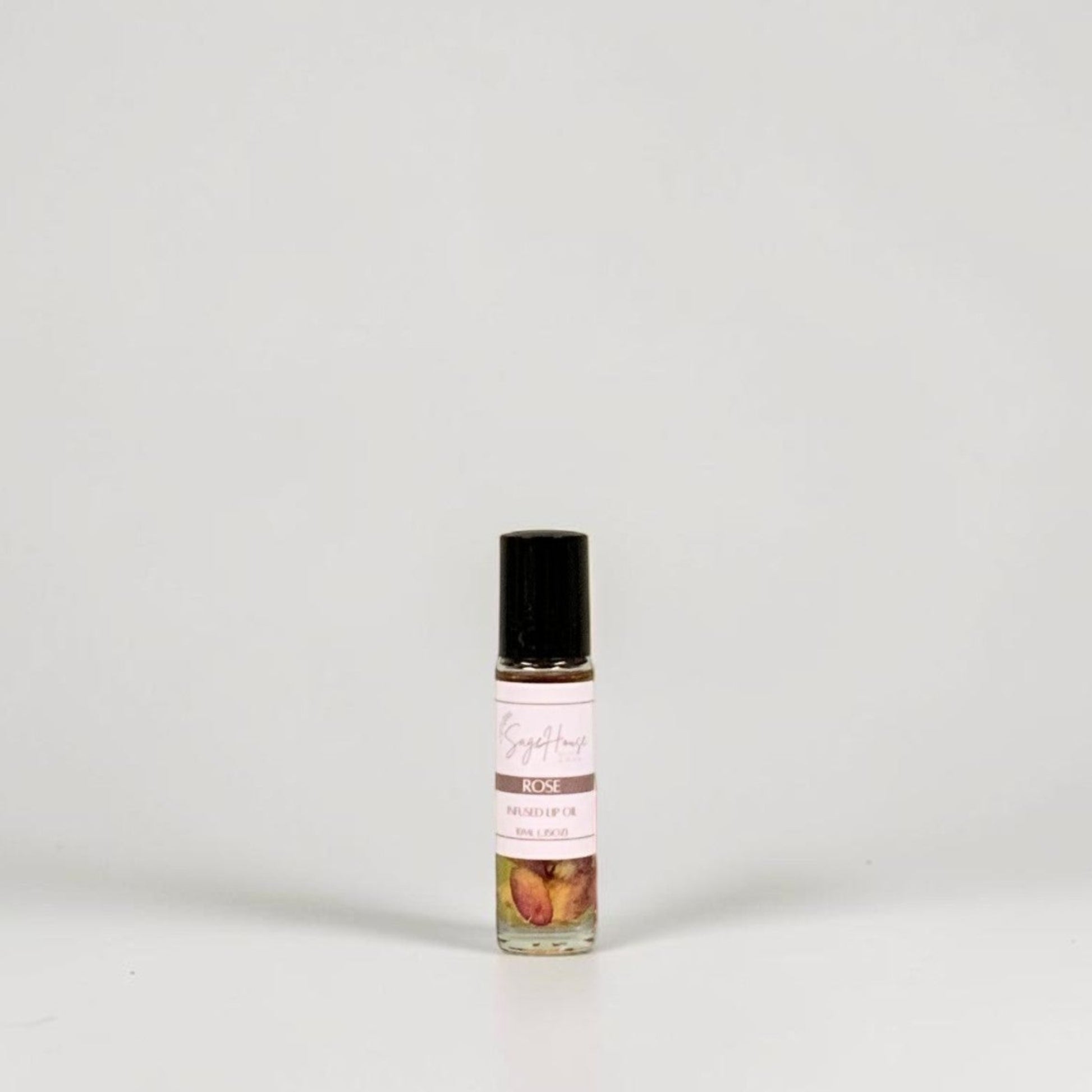 A small glass roller bottle with a black cap and a white label, standing on a light gray background.