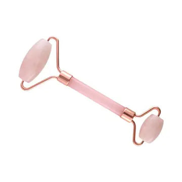 A rose quartz roller with gold handles and rollers on each end