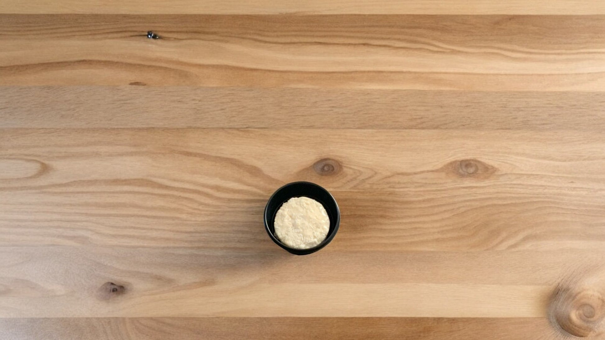 Shampoo bar travel case with a bar displayed inside. On a wooden surface. Shampoo bar sold separately